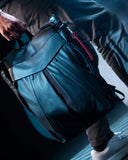 Morral THE FRENCHIE CO Leather Anti-Theft Speed Backpack en cuero italiano negro, con modelo, detalle del acceso lateral